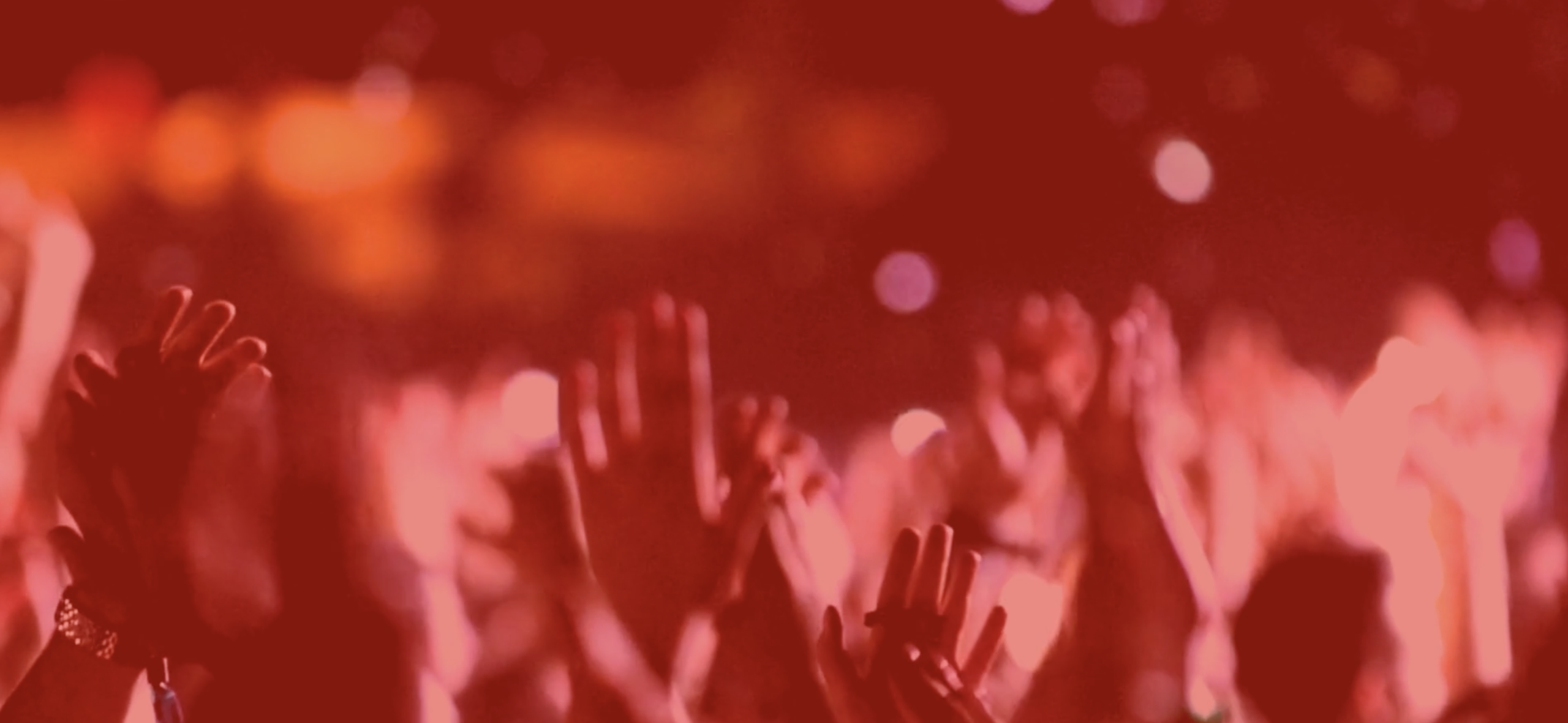 Hands lifted in the air with red color overlay