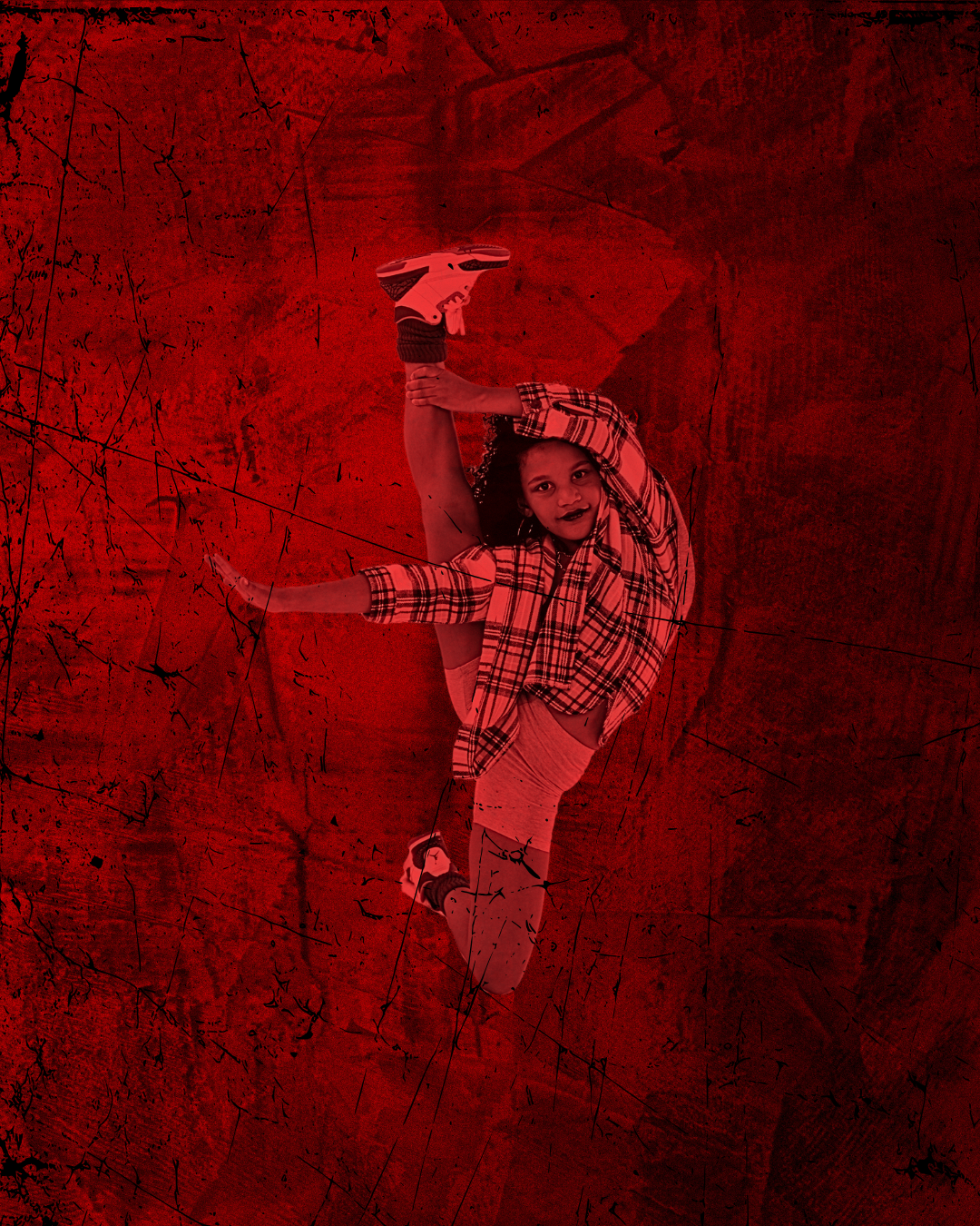 Female dancer posed holding leg in the air with red lighting and red background